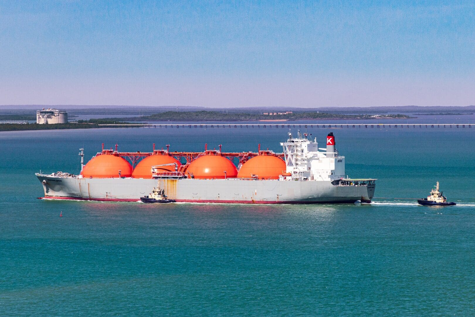 A large boat with orange tanks in the water.